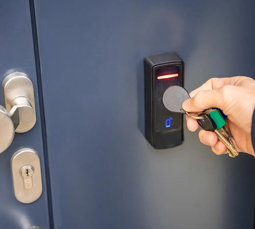 Zutrittskontrolle Einzelhandel - Mann hält Chip an Zutrittskontrolle
